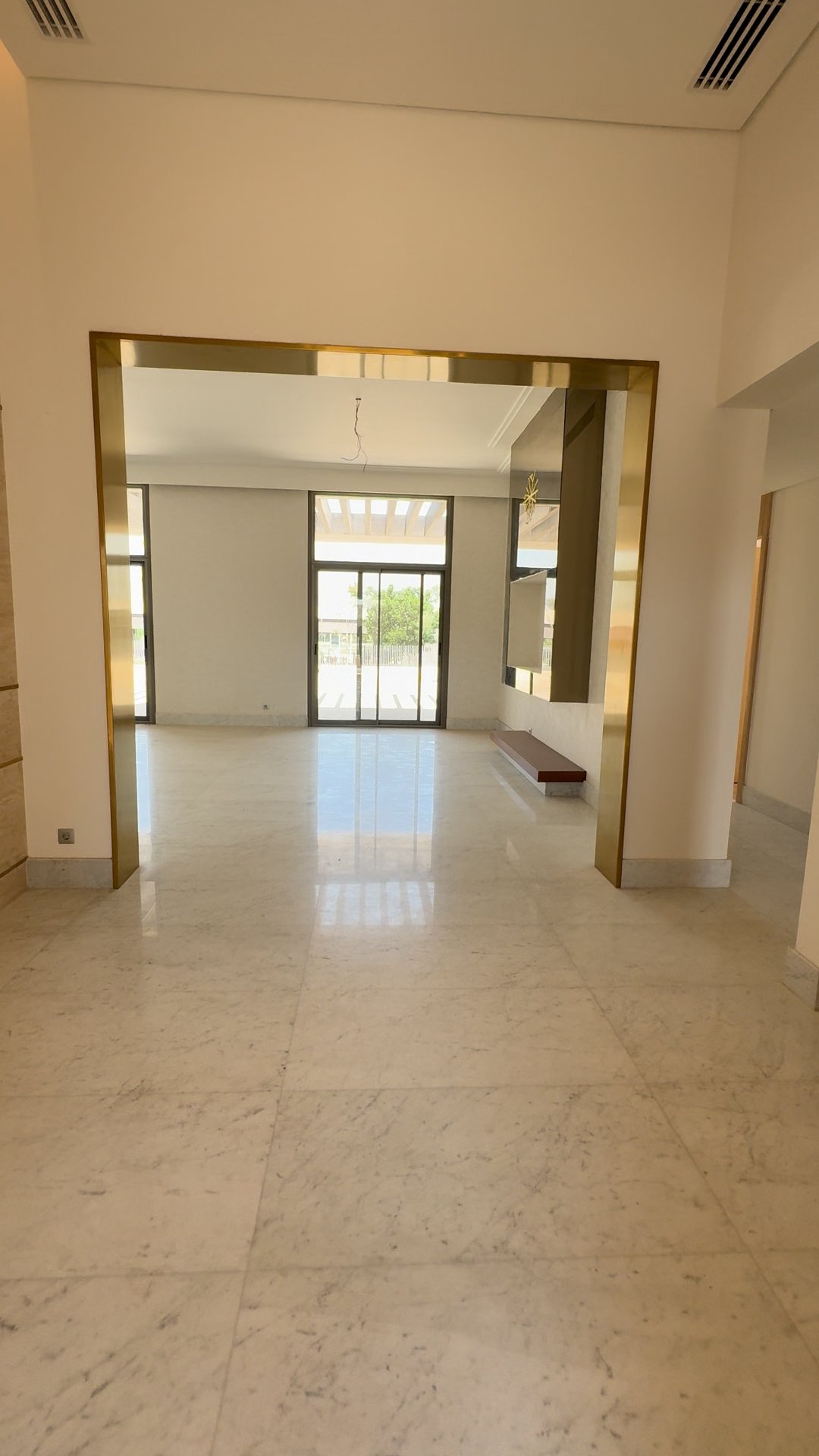 Brass-framed portal to living hall